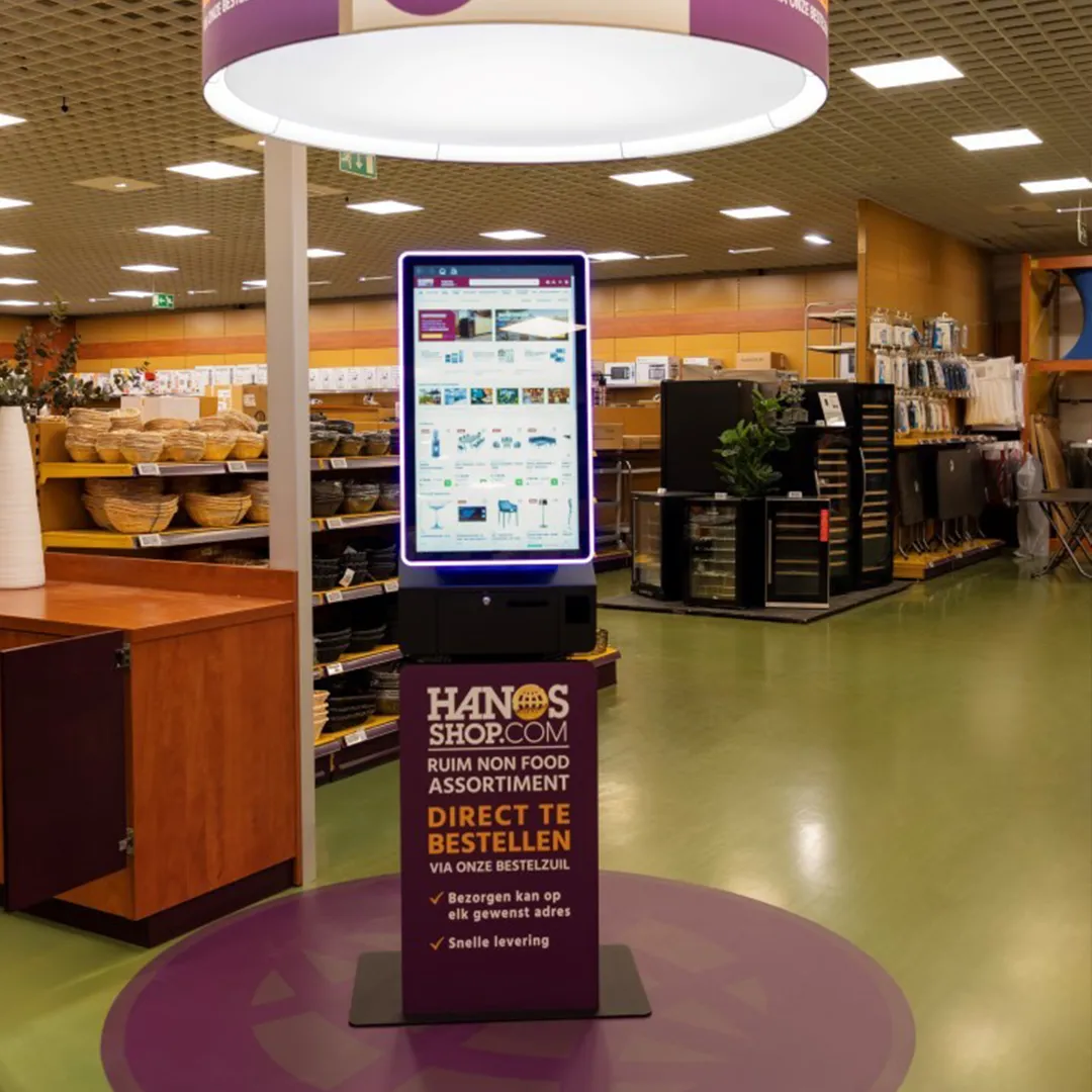 Bestelzuil van HANOS SHOP in een vestiging, ontworpen en geleverd door Prestop, met op maat gemaakte posterplaat en geïntegreerde software.