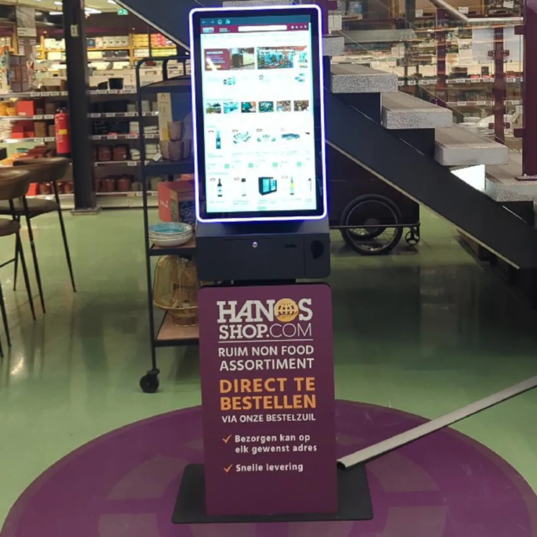 Bestelzuil van HANOS SHOP in een vestiging, ontworpen en geleverd door Prestop, met op maat gemaakte posterplaat en geïntegreerde software.