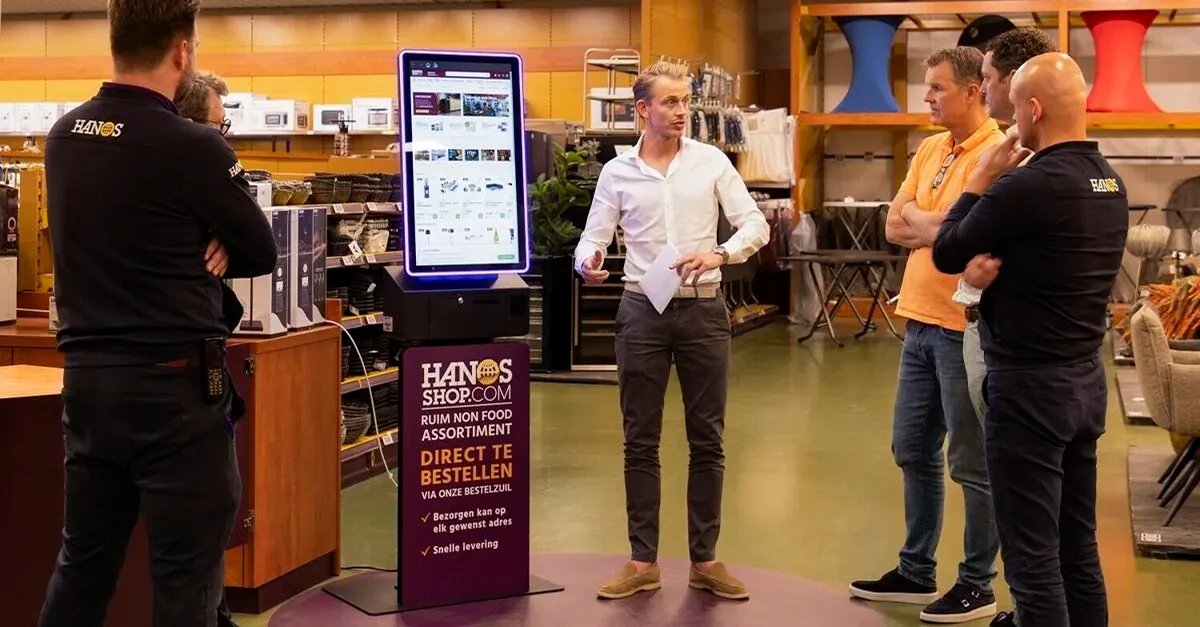Bestelzuil van HANOS SHOP in een vestiging, ontworpen en geleverd door Prestop, met op maat gemaakte posterplaat en geïntegreerde software.